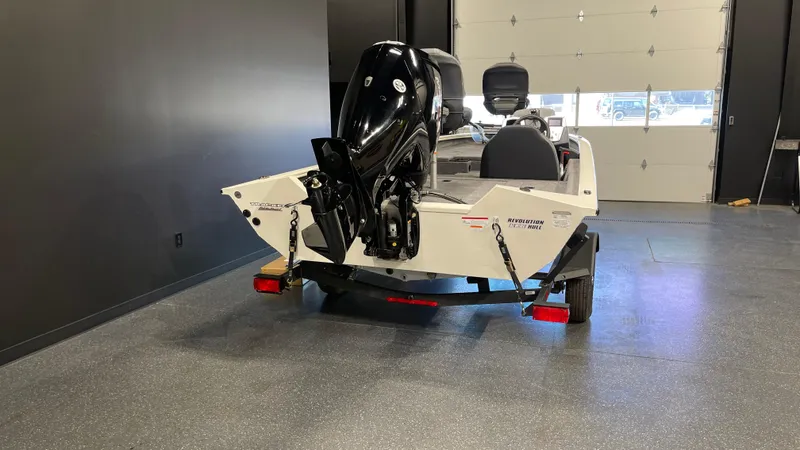 Slide: The Image of 2025 Tracker Pro Team 175 boat in garage, rear view with motor. - 4
