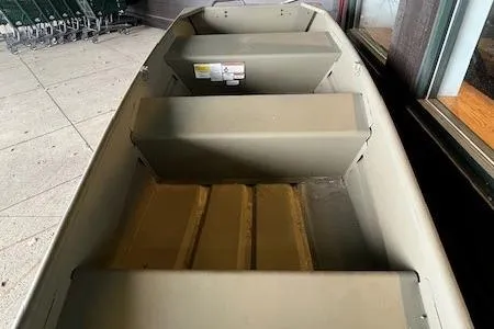 Slide: The Image of 2025 Tracker Grizzly 1036 Utility boat interior with bench seats, displayed indoors. - 3