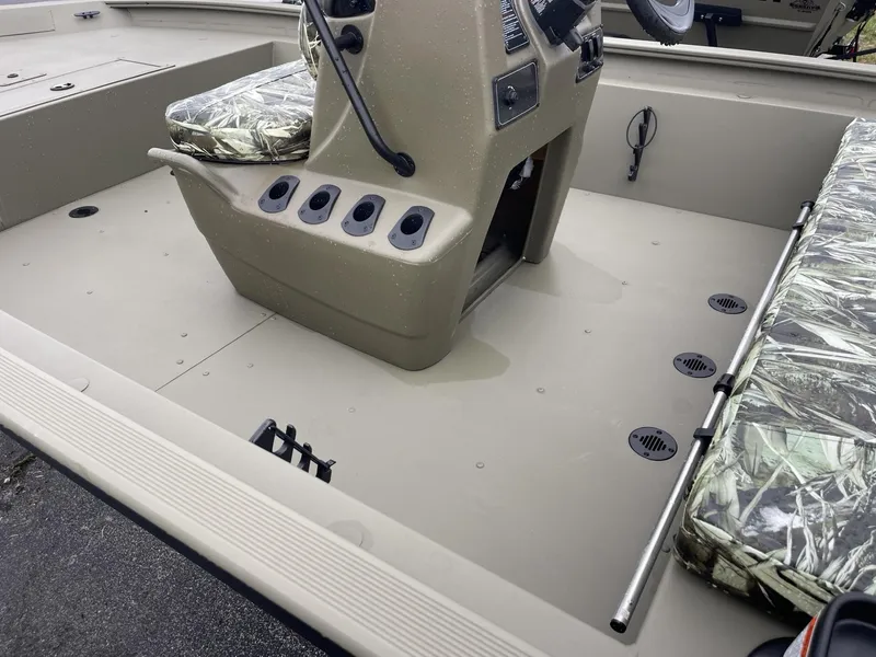 Slide: The Image of 2025 Tracker Grizzly 1860 CC boat interior with camo seats and steering console. - 6