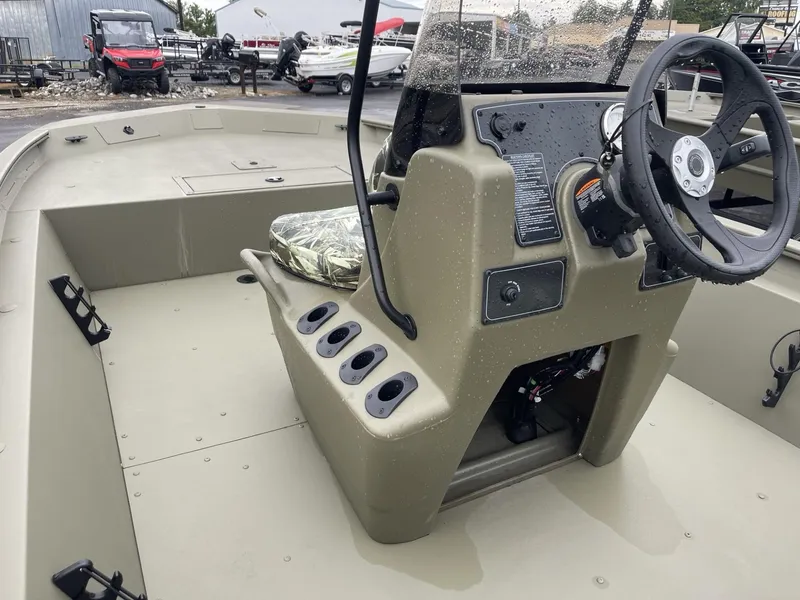 Slide: The Image of 2025 Tracker Grizzly 1860 CC boat interior with steering console and seating. - 7