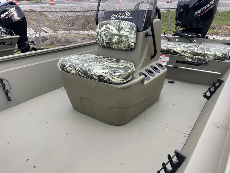 Slide: The Image of 2025 Tracker Grizzly 1860 CC boat interior with camo seats and Mercury outboard motor. - 9