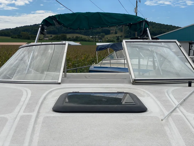 Slide: The Image of 2000 Bayliner 2352 Capri DX/LX boat with open windshield and green canopy. - 10
