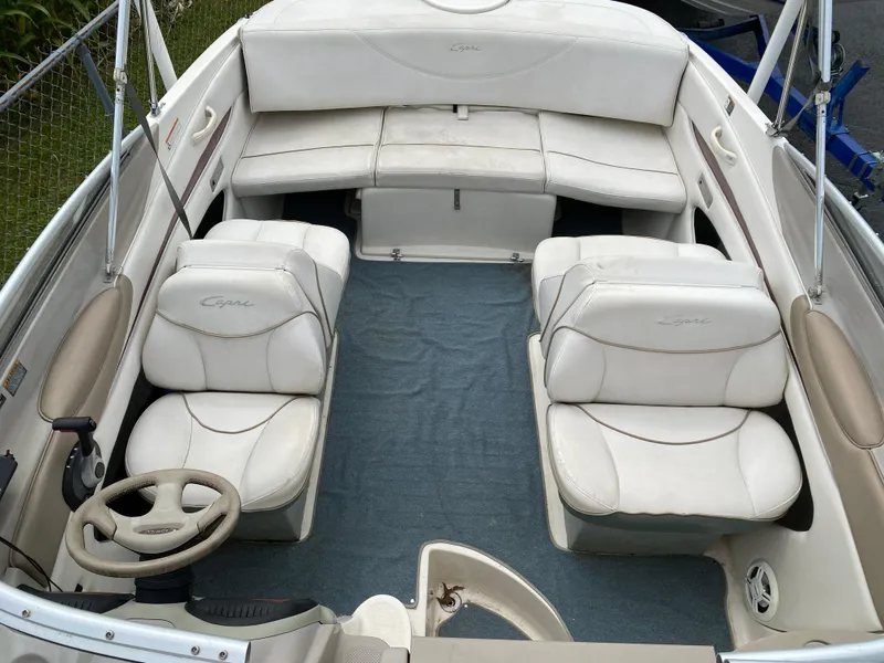 Slide: The Image of 2000 Bayliner 2352 Capri DX/LX boat interior with white seating and steering wheel. - 13