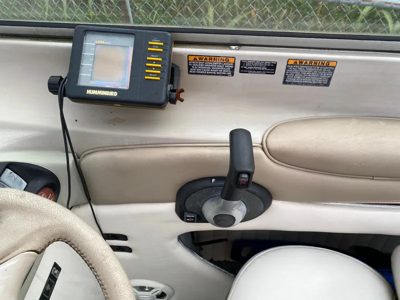 Slide: The Image of 2000 Bayliner 2352 Capri DX/LX boat dashboard with Humminbird fish finder and control lever. - 17