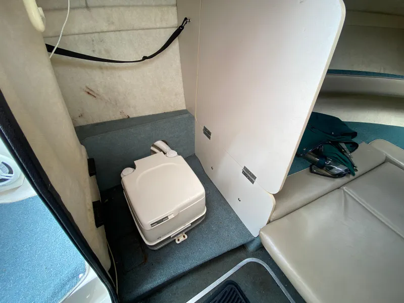 Slide: The Image of Interior of 2000 Bayliner 2352 Capri DX/LX with portable toilet and seating area. - 22