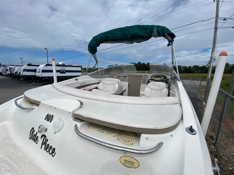 Slide: The Image of 2000 Bayliner 2352 Capri DX/LX boat with green canopy in outdoor storage. - 31