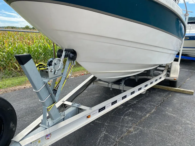 Slide: The Image of 2000 Bayliner 2352 Capri DX/LX boat on trailer, parked on asphalt. - 36