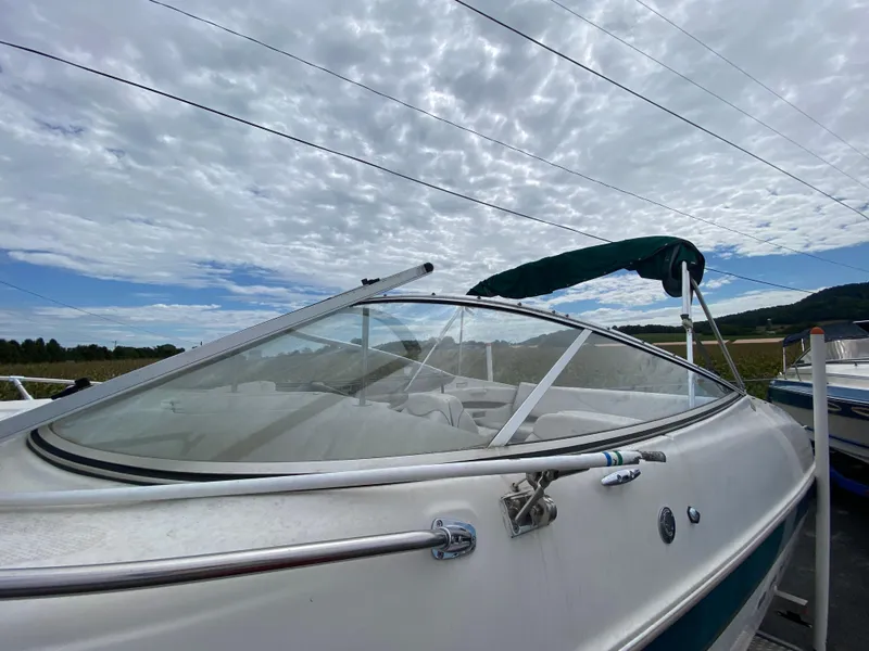 Slide: The Image of 2000 Bayliner 2352 Capri DX/LX boat with canopy under cloudy sky. - 39