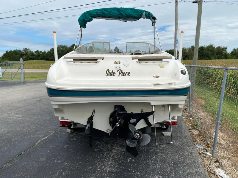 Slide: The Image of 2000 Bayliner 2352 Capri DX/LX boat with green canopy, parked on asphalt. - 41