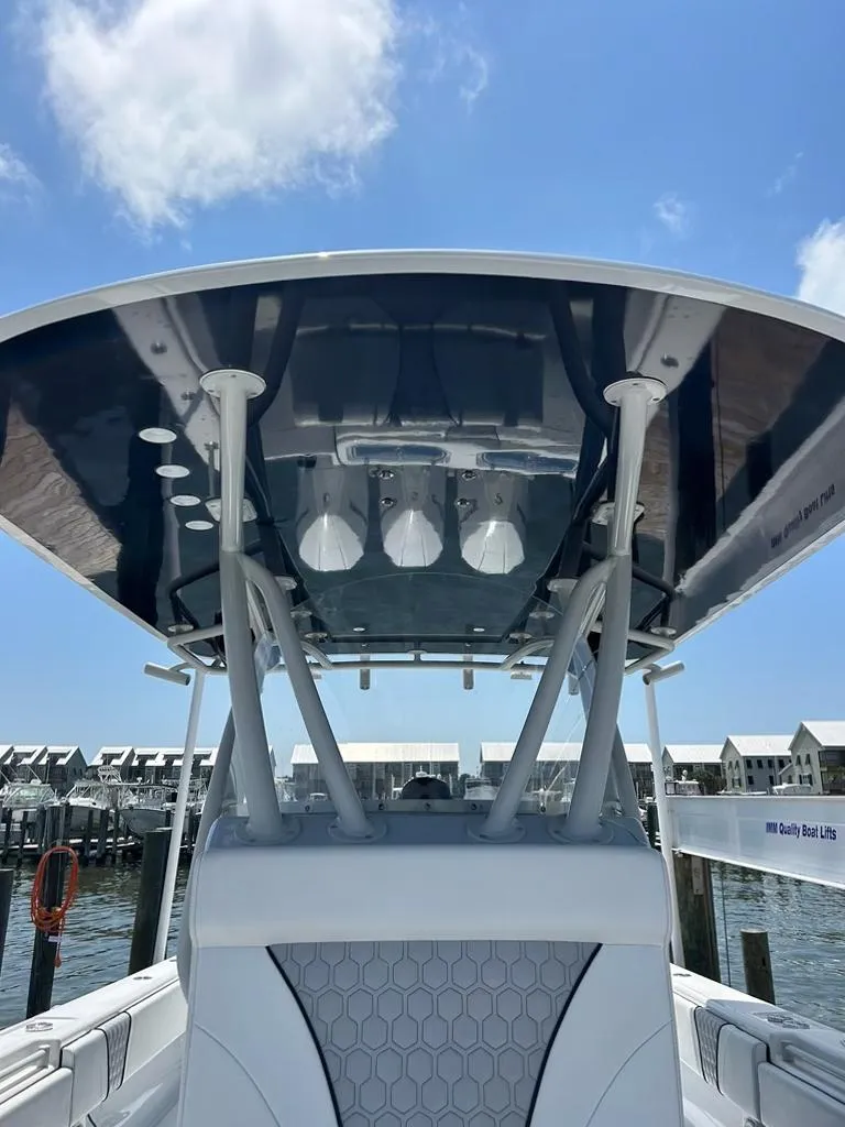 Slide: The Image of 2021 Contender 35 ST boat with sleek T-top design, docked under a clear blue sky. - 9