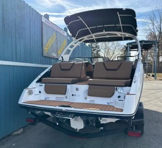 Slide: The Image of 2025 Yamaha Boats 252SD with brown seating and canopy, parked outdoors. - 3
