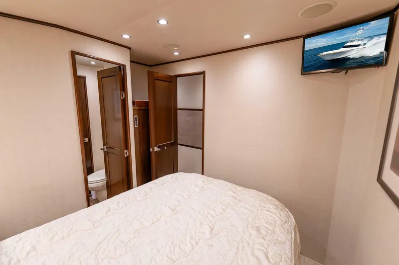 Slide: The Image of Interior of 2015 Viking 76 Convertible yacht bedroom with TV and ensuite bathroom. - 36