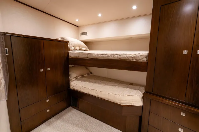 Slide: The Image of Cozy bunk beds in 2015 Viking 76 Convertible yacht cabin with wooden cabinetry. - 37