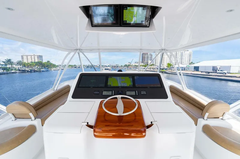 Slide: The Image of 2015 Viking 76 Convertible yacht helm with modern navigation system and waterfront view. - 42