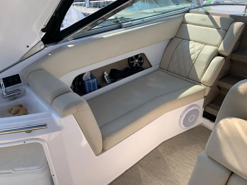 Slide: The Image of 2018 Regal 28 Express boat interior with beige seating and storage compartment. - 10
