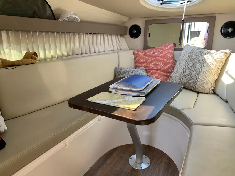 Slide: The Image of 2018 Regal 28 Express cabin interior with cozy seating and decorative pillows. - 22