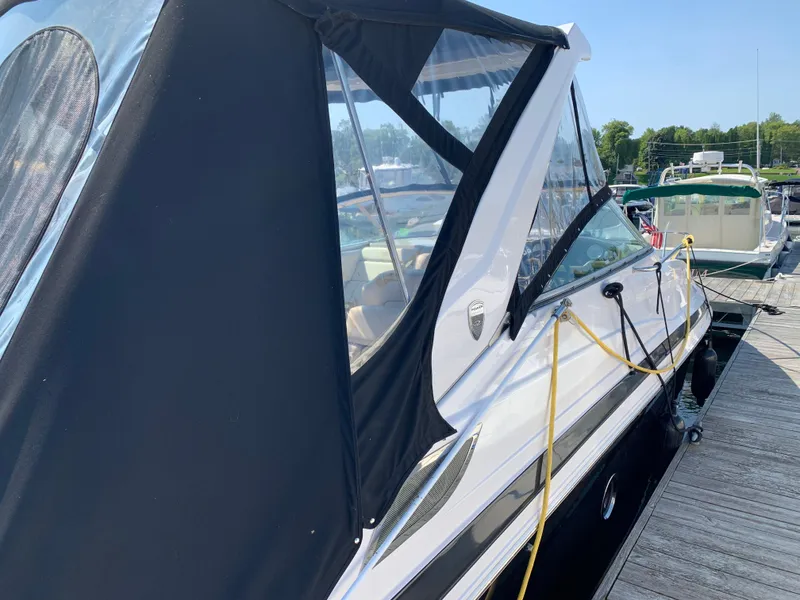 Slide: The Image of 2018 Regal 28 Express boat docked with black canopy and clear windows. - 6