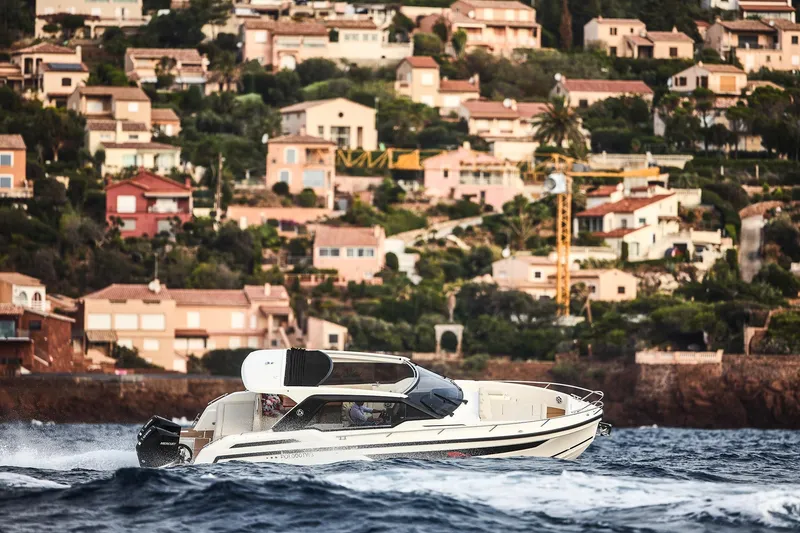 Slide: The Image of 2024 Skamander Sorrento boat cruising near coastal homes. - 16