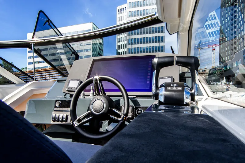 Slide: The Image of 2024 Skamander Sorrento boat cockpit with modern steering and navigation controls, cityscape background. - 28
