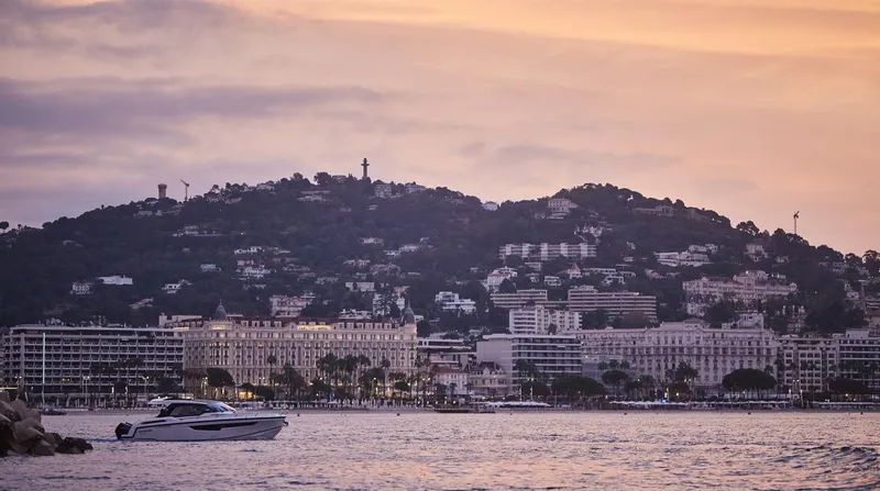 Slide: The Image of A Skamander Sorrento 2024 yacht cruising near a coastal city at sunset. - 3