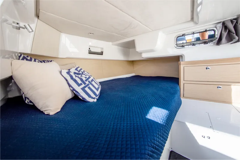 Slide: The Image of 2024 Skamander Sorrento cabin interior with blue bedding and wooden storage drawers. - 39
