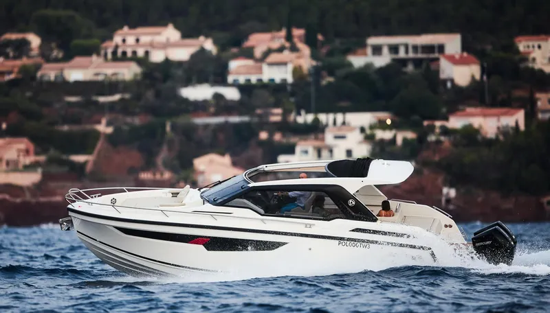 Slide: The Image of 2024 Skamander Sorrento boat cruising on the water with coastal homes in the background. - 4