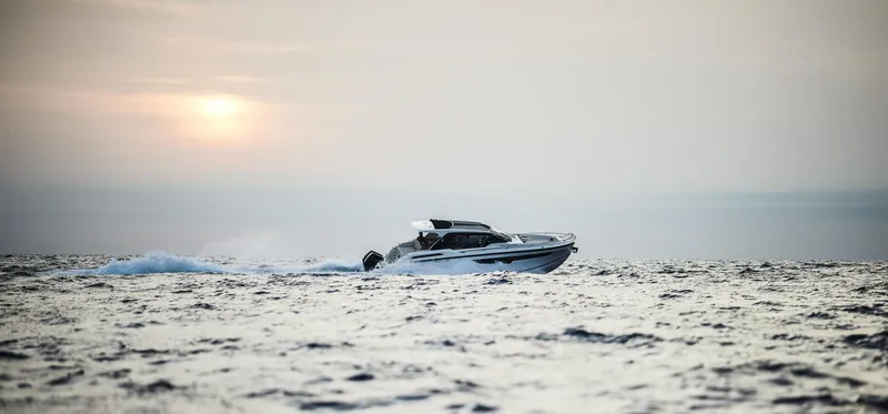 Slide: The Image of 2024 Skamander Sorrento boat cruising on open water at sunset. - 6