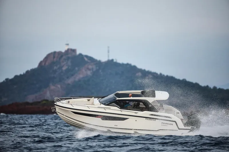 Slide: The Image of 2024 Skamander Sorrento boat cruising on open water with scenic mountain backdrop. - 7