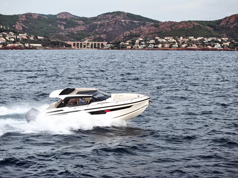 Slide: The Image of 2024 Skamander Sorrento boat cruising on the ocean with scenic coastal backdrop. - 9