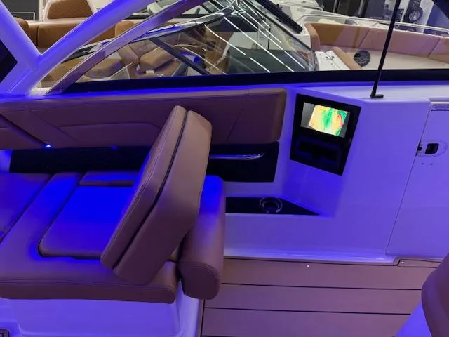 Slide: The Image of 2025 Chaparral 310 OSX interior with blue lighting and modern dashboard. - 14