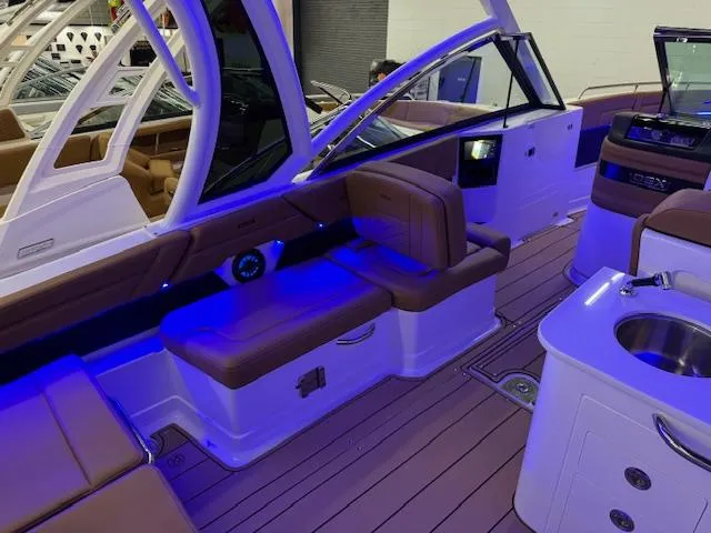 Slide: The Image of 2025 Chaparral 310 OSX boat interior with modern seating and ambient lighting. - 17