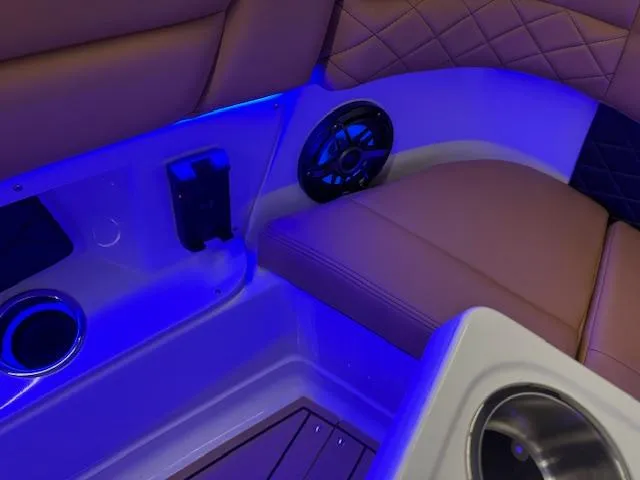 Slide: The Image of 2025 Chaparral 310 OSX boat interior with blue LED lighting and cushioned seating. - 3