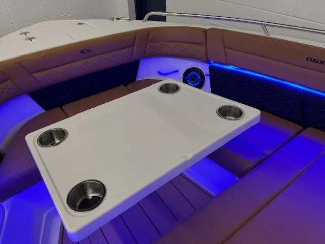 Slide: The Image of 2025 Chaparral 310 OSX boat interior with table and blue LED lighting. - 4