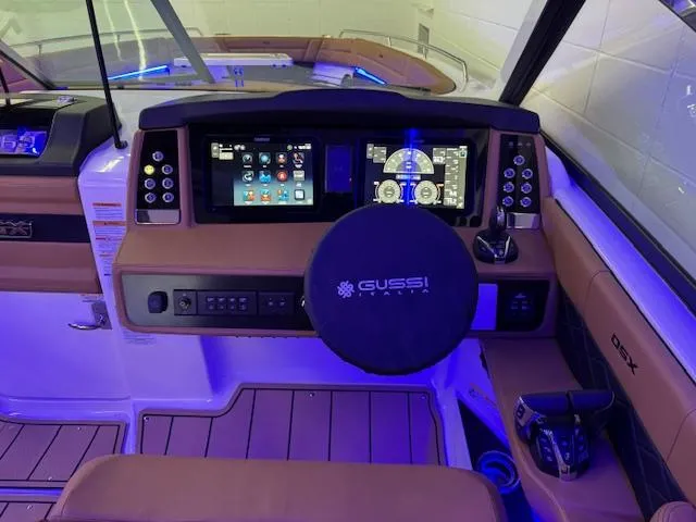 Slide: The Image of 2025 Chaparral 310 OSX boat cockpit with advanced navigation system and illuminated controls. - 9