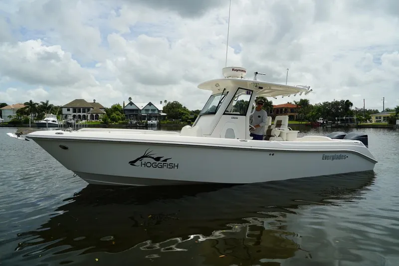 Slide: The Image of 2011 Everglades 295 boat on calm water, overcast sky, residential backdrop. - 0