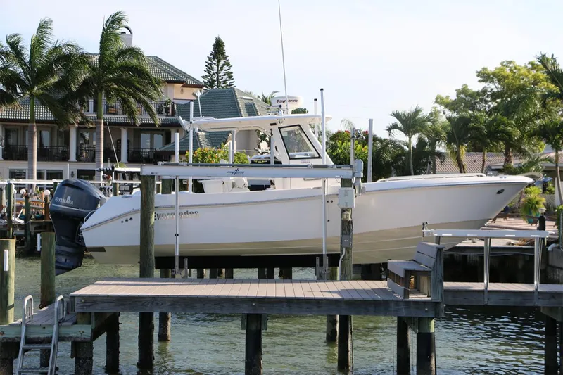Slide: The Image of 2011 Everglades 295 boat docked near waterfront homes with palm trees. - 10