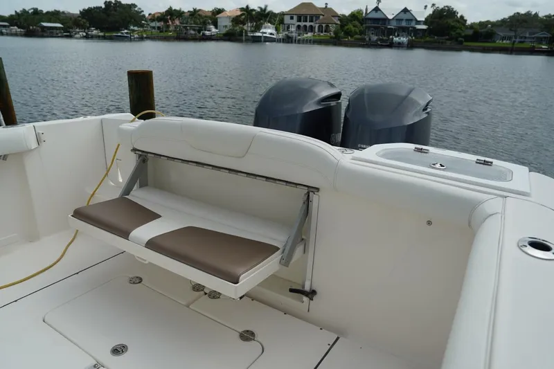 Slide: The Image of 2011 Everglades 295 boat with dual engines and foldable seating by a lake. - 13