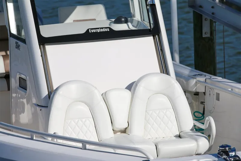 Slide: The Image of 2011 Everglades 295 boat with white leather seats, docked by the water. - 25