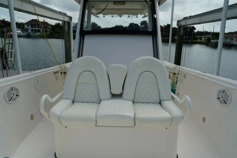 Slide: The Image of 2011 Everglades 295 boat interior with white cushioned seating and waterfront view. - 26