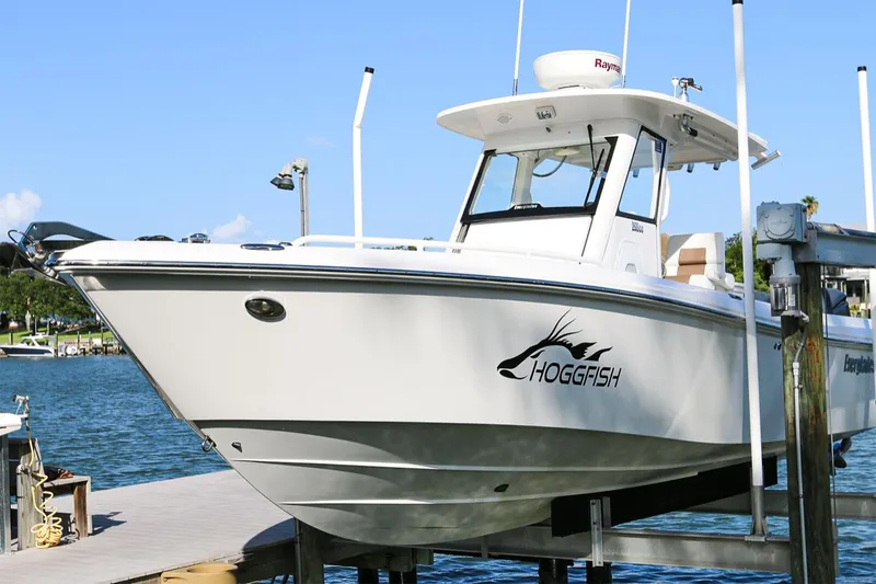 Slide: The Image of 2011 Everglades 295 boat docked, featuring "Hogfish" logo, clear blue sky background. - 35