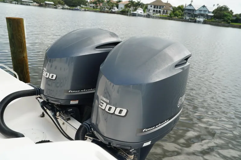 Slide: The Image of Twin Yamaha 300 outboard engines on a 2011 Everglades 295 boat by the water. - 9