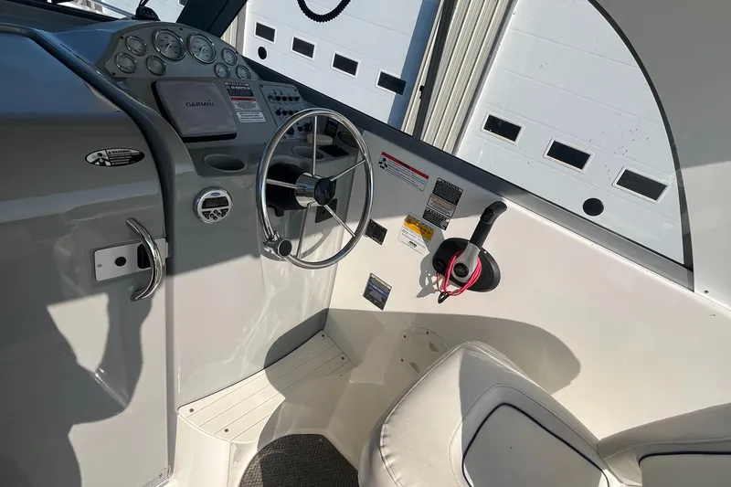 Slide: The Image of 2011 Bayliner 266 Discovery boat cockpit with steering wheel and control panel. - 10