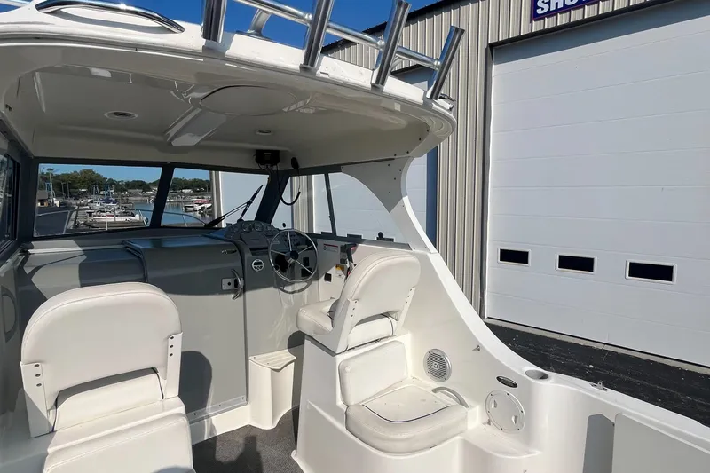Slide: The Image of 2011 Bayliner 266 Discovery boat interior with helm and seating area. - 11