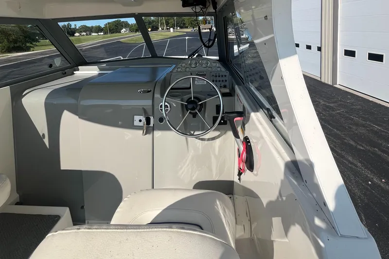 Slide: The Image of 2011 Bayliner 266 Discovery boat cockpit with steering wheel and dashboard controls. - 15