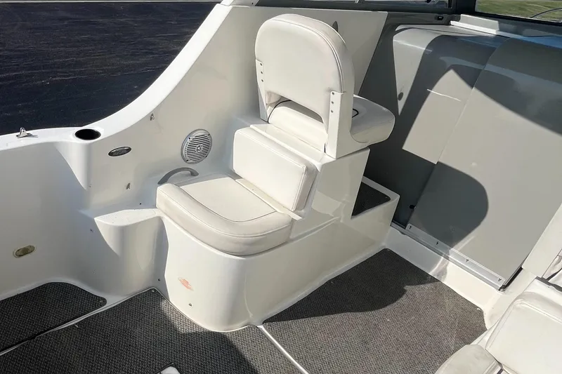 Slide: The Image of 2011 Bayliner 266 Discovery boat interior with white seating and gray flooring. - 17