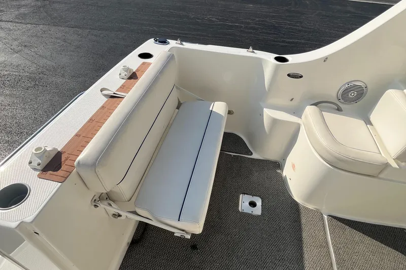 Slide: The Image of 2011 Bayliner 266 Discovery boat interior with white seating and deck details. - 18