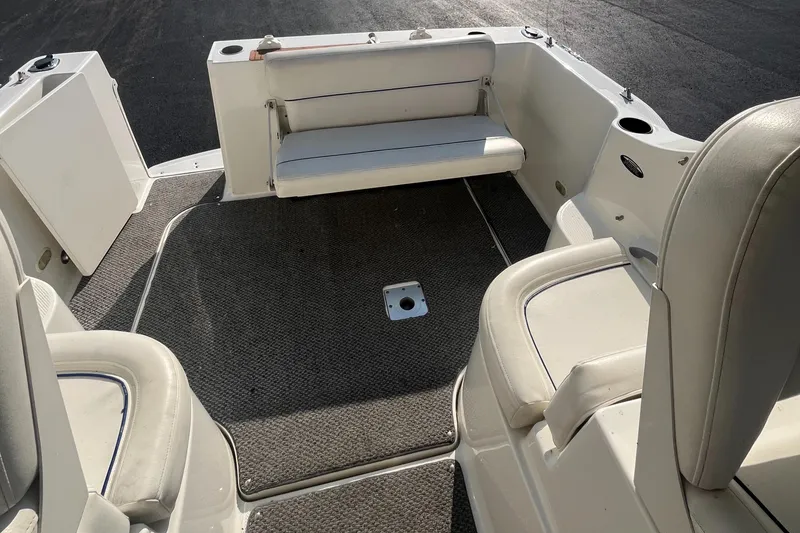 Slide: The Image of 2011 Bayliner 266 Discovery boat interior with cushioned seating and carpeted flooring. - 21