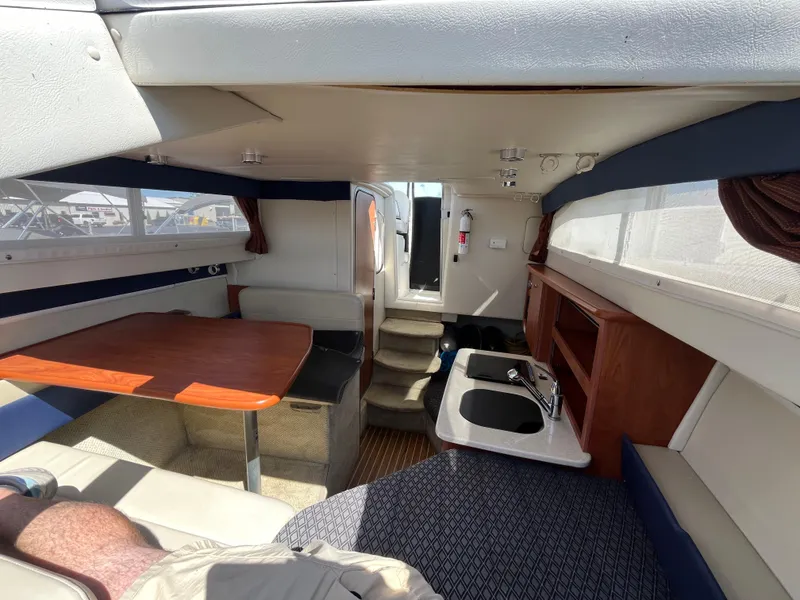 Slide: The Image of Interior of 2011 Bayliner 266 Discovery boat with seating, table, and kitchenette. - 22