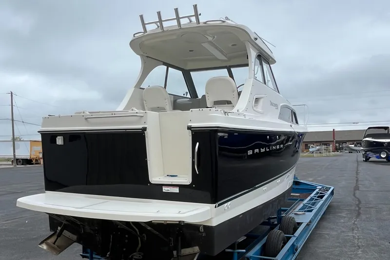 Slide: The Image of 2011 Bayliner 266 Discovery boat on trailer, rear view, overcast sky. - 5