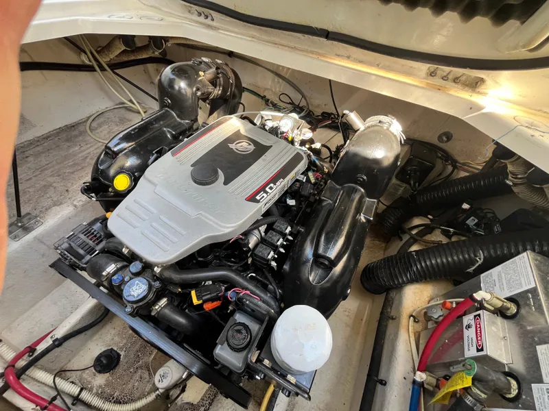 Slide: The Image of Engine compartment of a 2011 Bayliner 266 Discovery boat, showcasing the engine and wiring. - 7